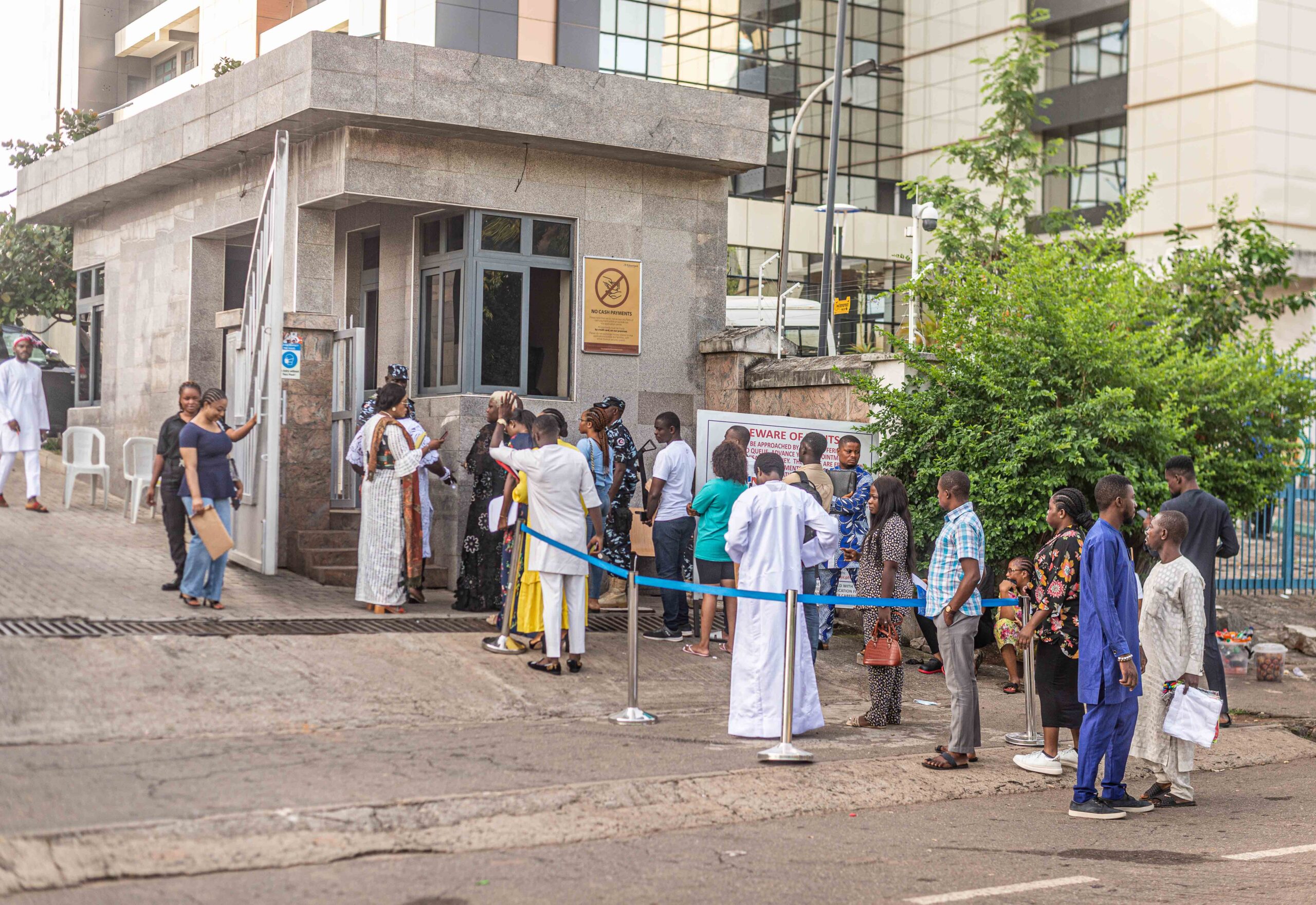 Visa applicants stand in line, anticipating entry into the visa office in Muktar El Yakub Plaza Abuja. Photo by David Exodus