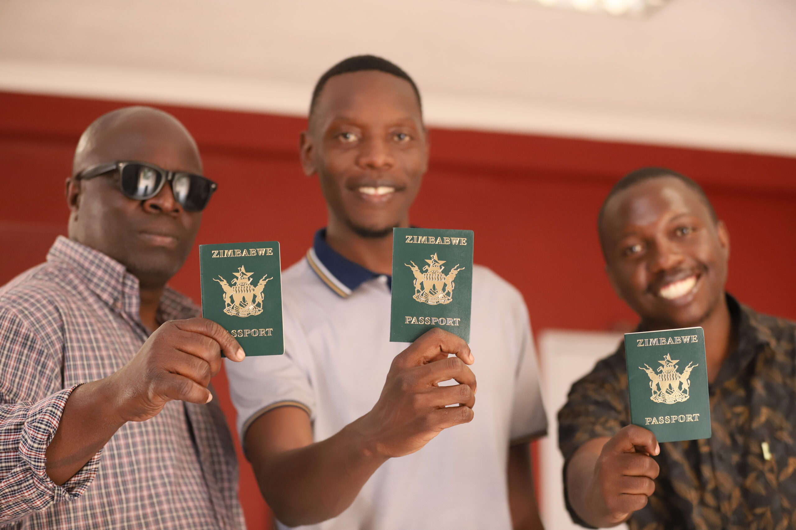 Zimbabwean men showing off their passports as they plan to leave Zimbabwe for Greener pastures. Photo by Shepherd Tozvireva